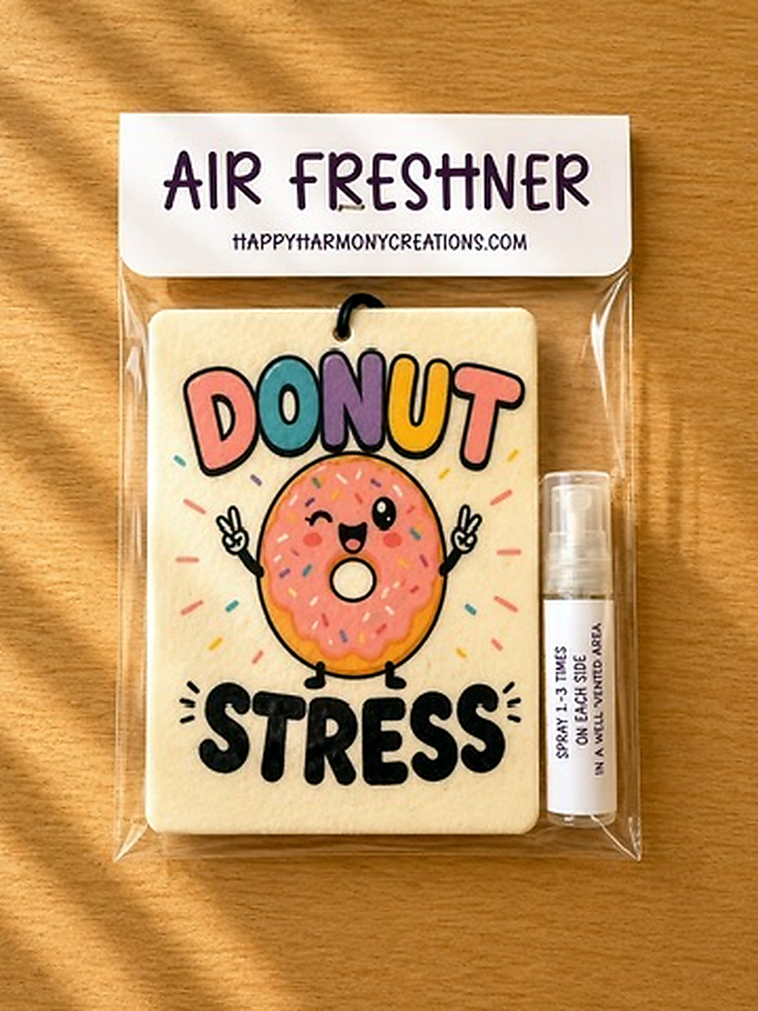 packaged rectangular air freshener with donut stress artwork and scent bottle